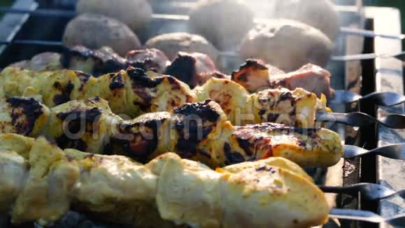 烤串上的烤串和土豆在烤炉里的煤上煮熟视频的预览图