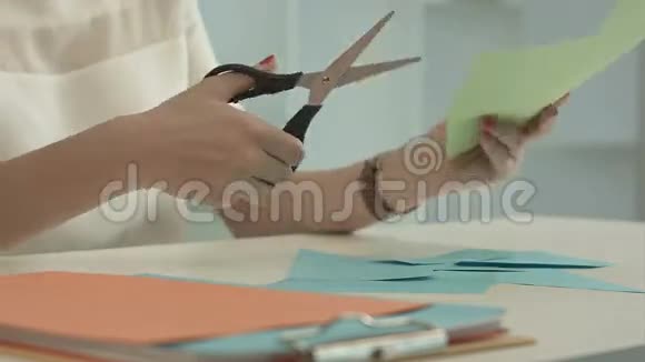 女人用剪刀剪绿纸视频的预览图