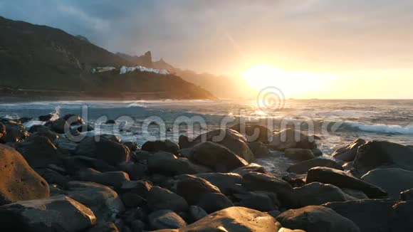 海浪撞击岩石在美丽的日落光线下缓慢地喷射贝尼霍海滩位于加那利视频的预览图