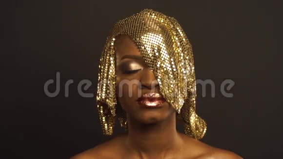 神奇超现实的金色非裔美国女性模特亮晶晶的妆容和光滑的金色发型视频的预览图