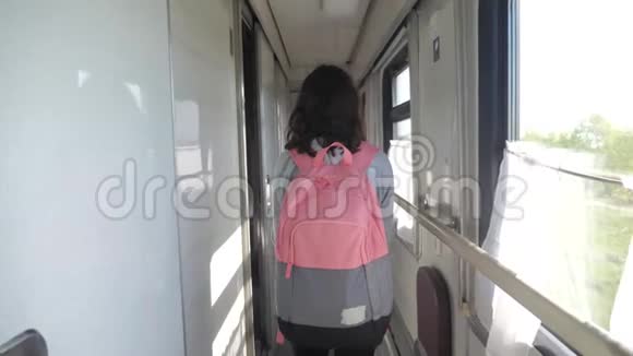 十几岁的女孩带着背包在火车车厢里散步旅游运输铁路概念小女孩走路视频的预览图