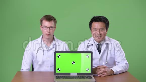 两名多民族医生在绿色背景下视频的预览图