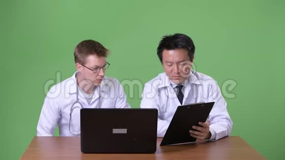 两名多民族医生在绿色背景下视频的预览图
