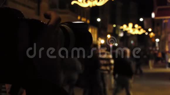 摄影师在晚上拍摄一条拥挤的街道视频的预览图