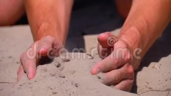 沙从男性手在海滩上缓慢运动男人手里的脏沙视频的预览图