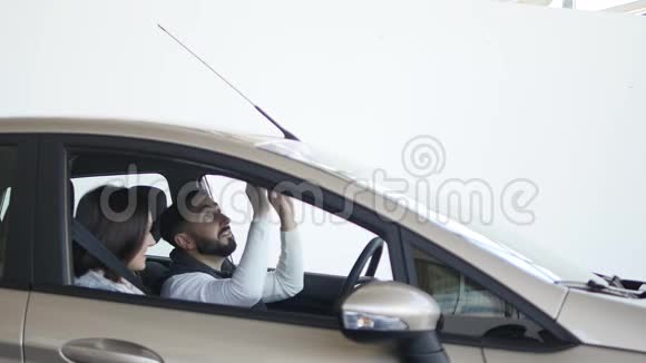 参观汽车经销商漂亮的一家人坐在新车里边说边笑视频的预览图