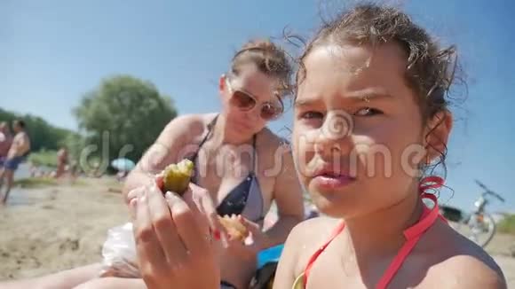 少女吃三明治海滩度假海水慢视频视频的预览图