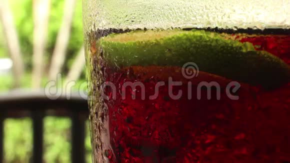 一杯中杯可乐色汽水和一张模糊的椅子视频的预览图
