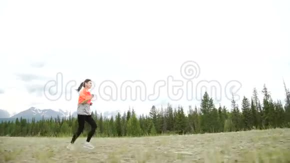 年轻的运动员在山路上奔跑波夫跟着凸轮自然中的日落锻炼慢动作视频的预览图