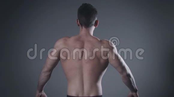 一个背部肌肉发达的人在演播室里摆姿势视频的预览图