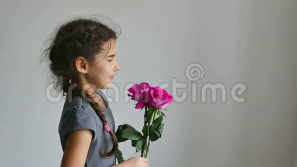 少女闻着白色背景的玫瑰花视频的预览图