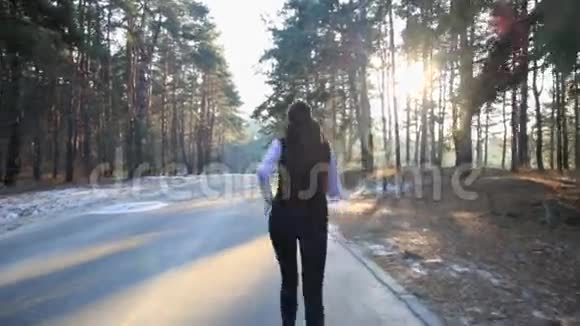 身材苗条的年轻女子在日出时从事体操她沿着森林奔跑视频的预览图