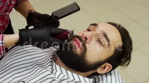 理发店的理发师用剪子修剪客户的胡须视频的预览图