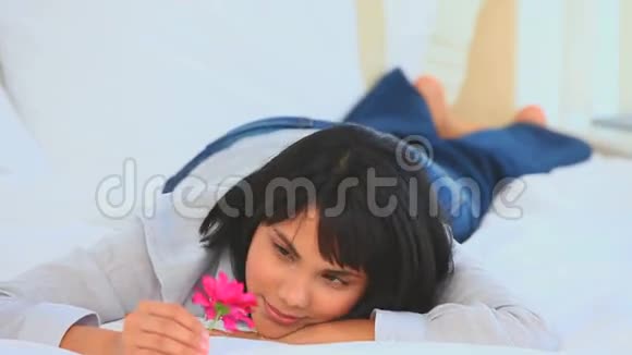 可爱的亚洲女人捧着一朵粉红色的花视频的预览图