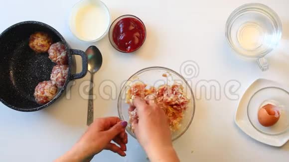 这位妇女在肉末肉丸的手中形成加入了米饭鸡蛋和奶酪把它们放进锅里视频的预览图