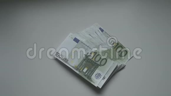 商人手里拿着100欧元的钞票在桌上视频的预览图