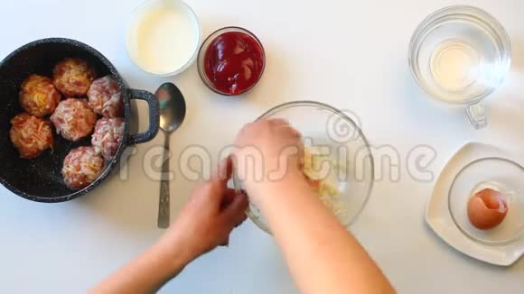 这位妇女在肉末肉丸的手中形成加入了米饭鸡蛋和奶酪把它们放进锅里视频的预览图