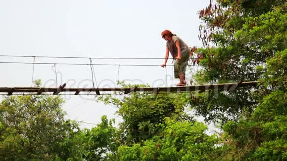 动物园潘旅游妇女穿越危险的竹吊桥视频的预览图