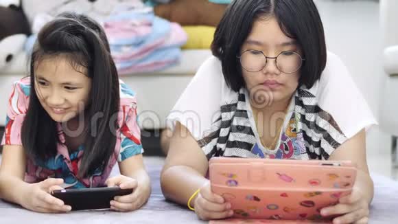 亚洲男孩和女孩一起玩手机游戏带着笑脸视频的预览图