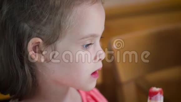 美丽的小女孩吃着美味的彩色冰淇淋视频的预览图
