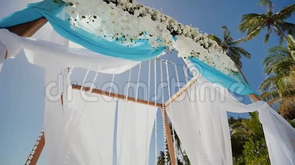 在热带海滩上装饰着鲜花和大型风发织物的婚礼拱门菲律宾博霍尔视频的预览图