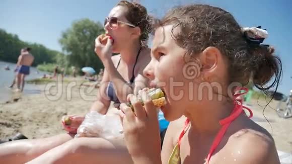 女孩海边吃青少年三明治度假水慢视频视频的预览图