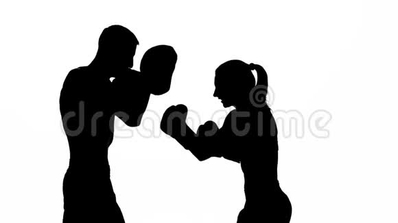 把那个家伙和那个女孩用拳击爪子抓起来剪影白色背景视频的预览图