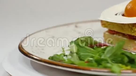 带草莓果酱和鲜奶油的维多利亚海绵蛋糕在白色背景上切下一块视频的预览图