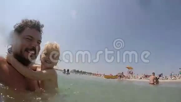金发小女孩和她父亲在水里玩视频视频的预览图