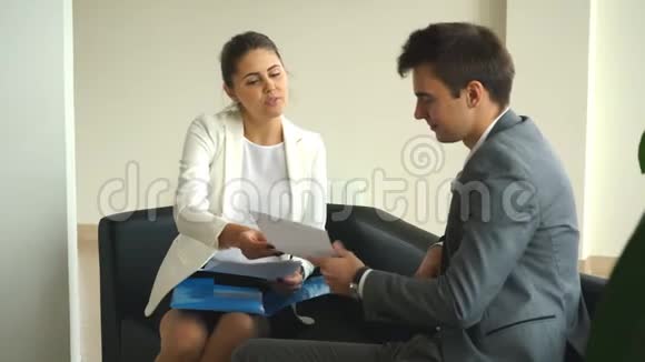 两位同事坐在办公室的椅子上讨论商业想法视频的预览图