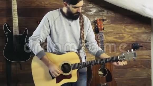 一个有胡子的人在调声吉他慢动作视频的预览图