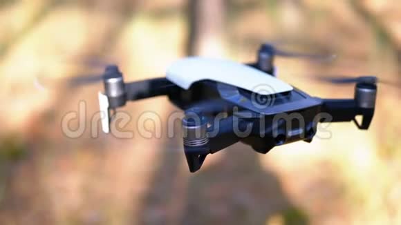 带着相机在空中盘旋的无人机在森林里的地面上飞慢动作视频的预览图