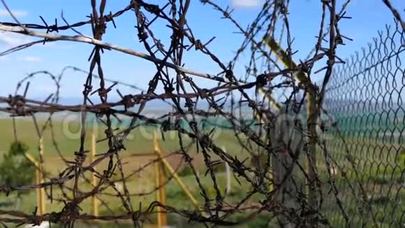 有刺铁丝网有刺铁丝网和蓝天的花园篱笆视频的预览图
