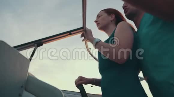 穿裙子的红发女孩和男人一起驾驶摩托艇夏日之夜浪漫浪漫视频的预览图