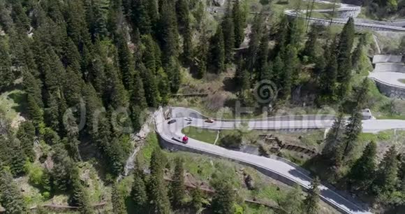 乘坐卡车和汽车在锯齿形上行驶的高山蛇形公路的鸟瞰图在欧洲瑞士上下行视频的预览图