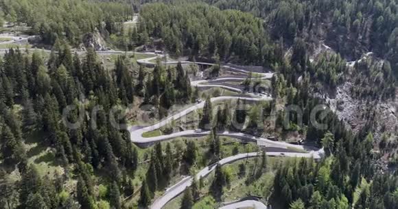乘坐卡车和汽车在锯齿形上行驶的高山蛇形公路的鸟瞰图在欧洲瑞士上下行视频的预览图
