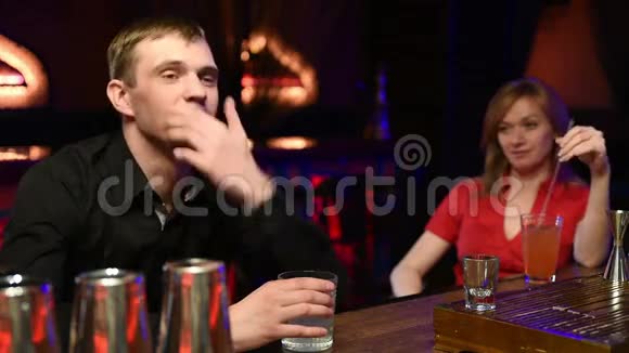 快乐的男人坐在酒吧里从烟囱里喝酒精视频的预览图