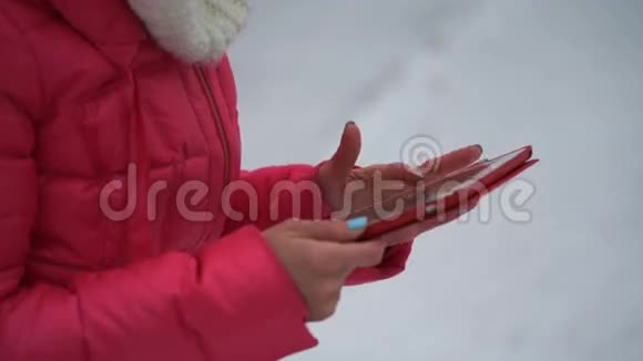 冬天在户外使用平板电脑的女性4k视频的预览图