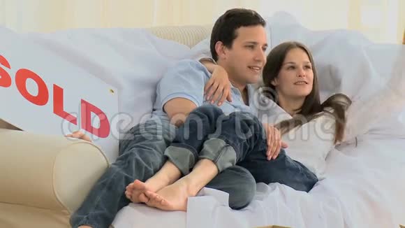 可爱的一对夫妇躺在沙发上接吻视频的预览图