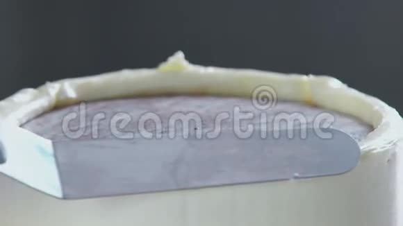 糖果师装饰蛋糕并用黄油霜覆盖它视频的预览图
