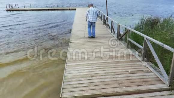 在湖边拄拐杖的残疾人视频的预览图