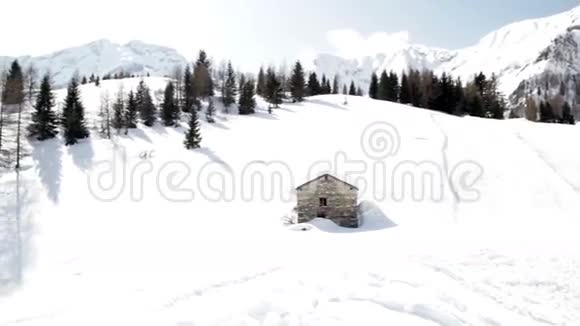 有小木屋和松树的雪山视频的预览图