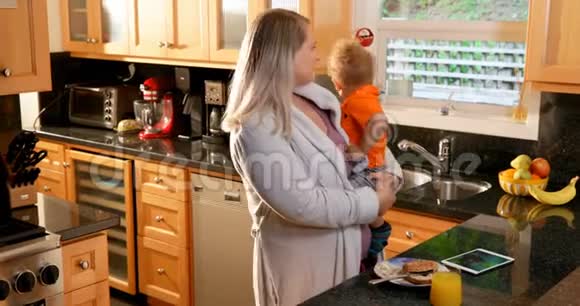 母亲把儿子抱在厨房里视频的预览图