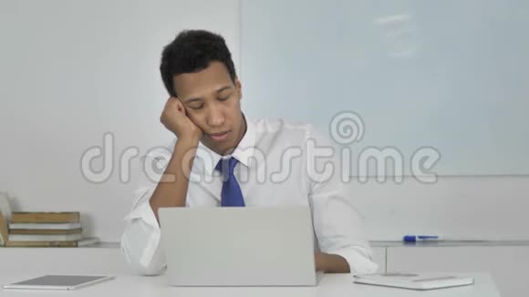 疲惫的非裔美国商人在工作中睡觉视频的预览图