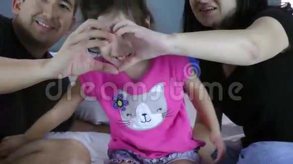 小女孩的脸在爸爸妈妈的手上心形的关爱教育和家庭之爱的象征视频的预览图