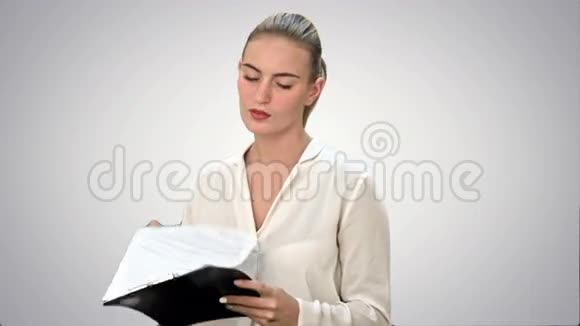 年轻的女商人在白色背景下阅读文件视频的预览图