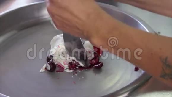 街头小贩用樱桃制作油炸冰淇淋的过程视频的预览图