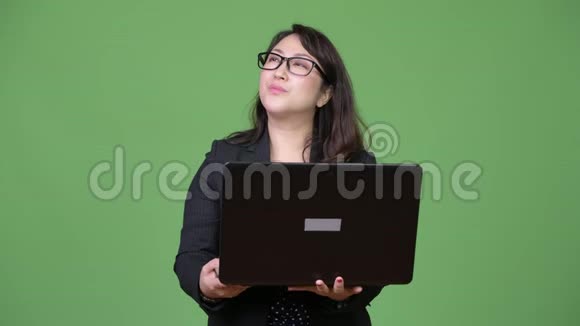 成熟漂亮的亚洲女商人绿色背景下使用笔记本电脑视频的预览图