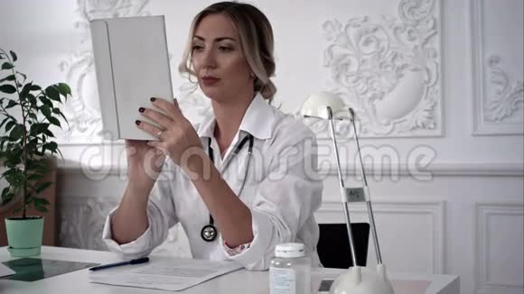 年轻的女医生在办公室工作平板电脑视频的预览图