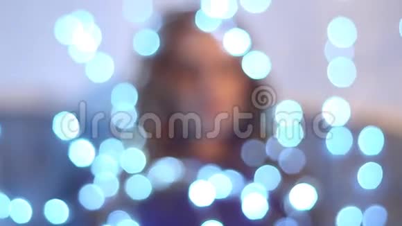 美丽的红发女孩笼罩在一个发光的圣诞灯泡视频的预览图